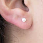 a model wearing a pearl stud earring