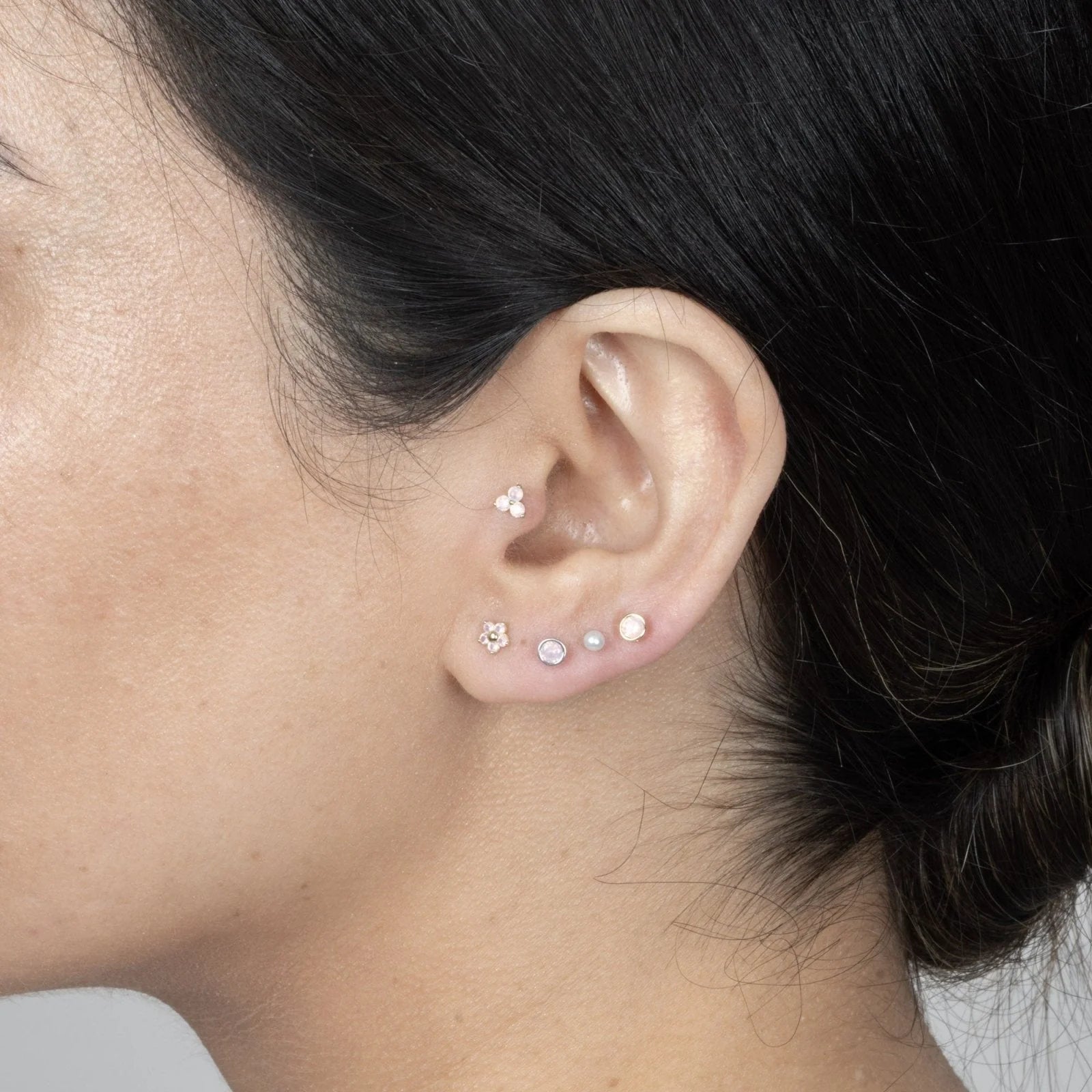 a model with an earring stack of five studs