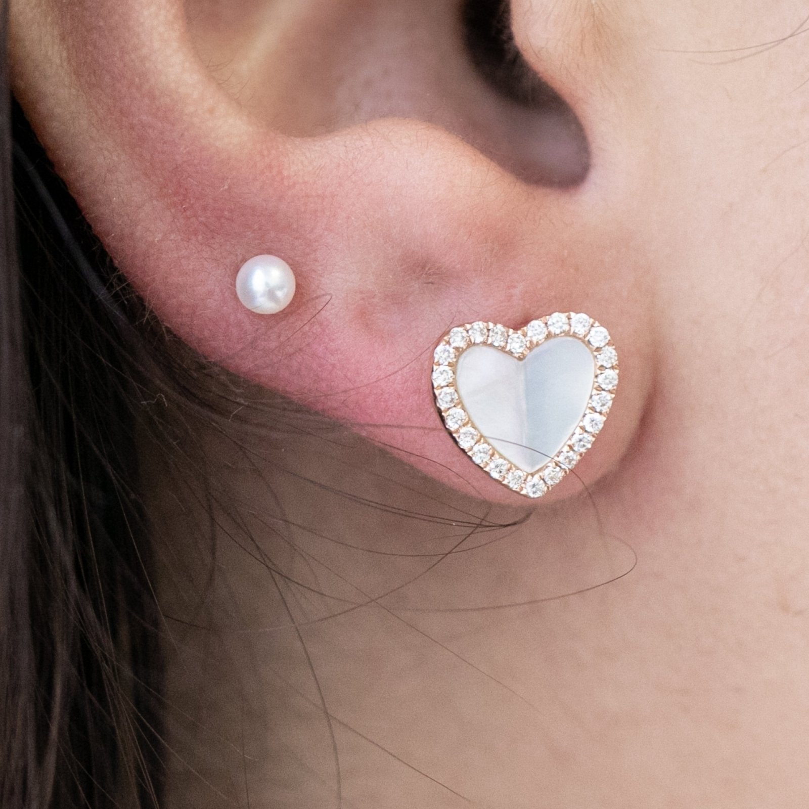 a pearl heart-shaped stud earring.