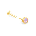 a pink opal stud earring removed from its backing