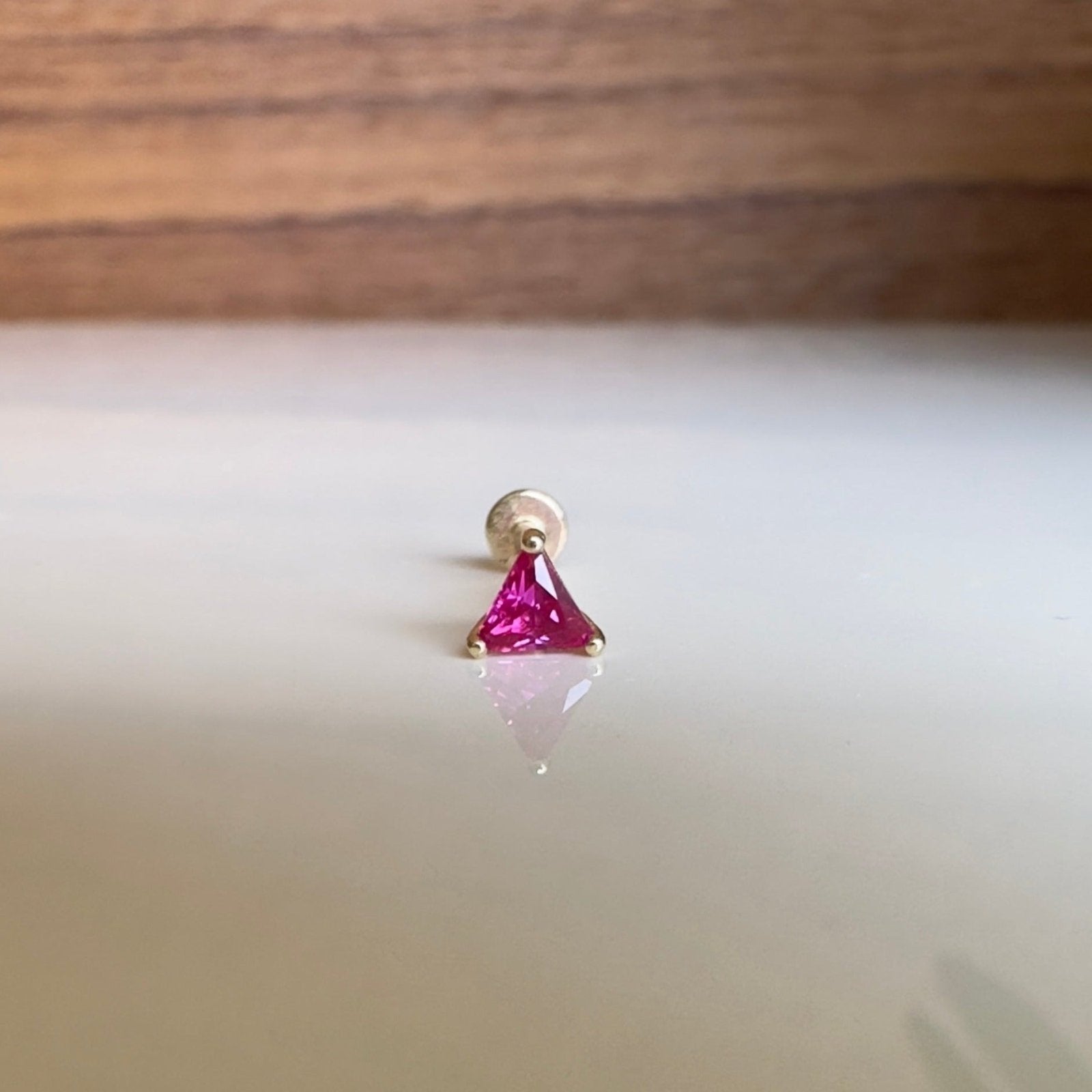 pink stud earring facing forward on white table