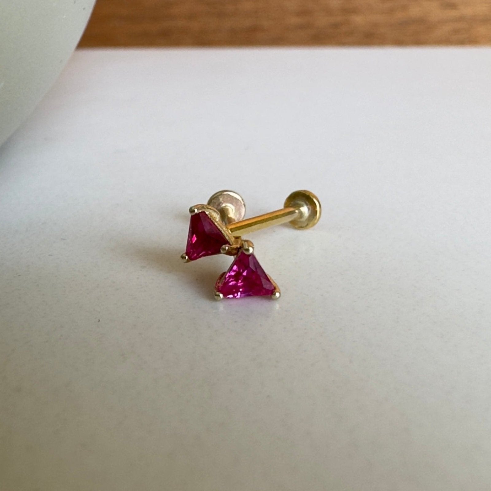 two pink studs on white table